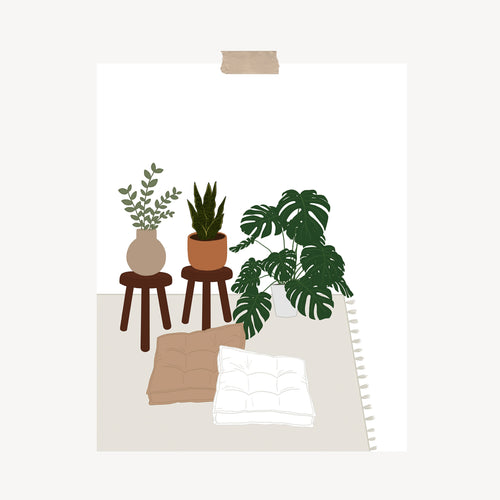 An art print featuring a monstera, snake plant, and eucalyptus plant on wooden stools and a rug next to two floor pillows hung with a piece of kraft tape on the top.