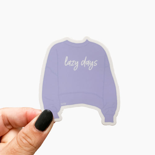 A sticker featuring a cozy lilac sweater and text that reads, Lazy days.