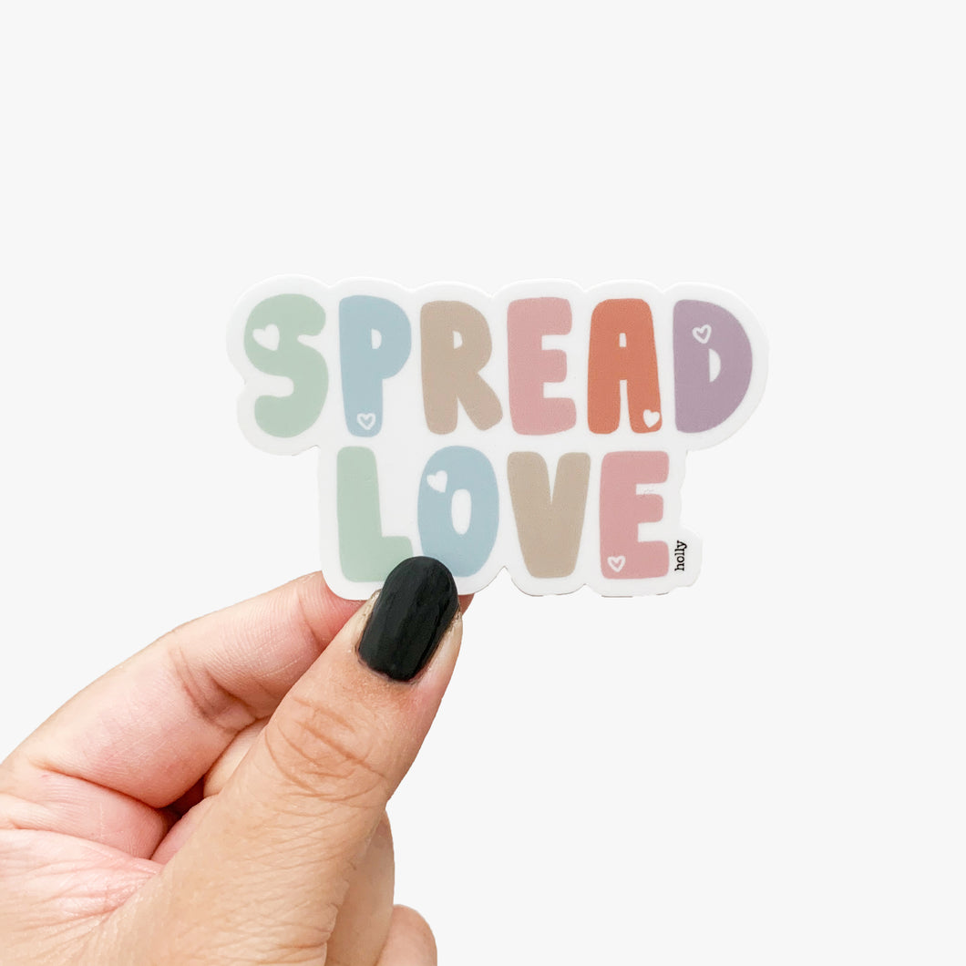 A colorful sticker with hearts on the bubble text that reads, Spread Love.